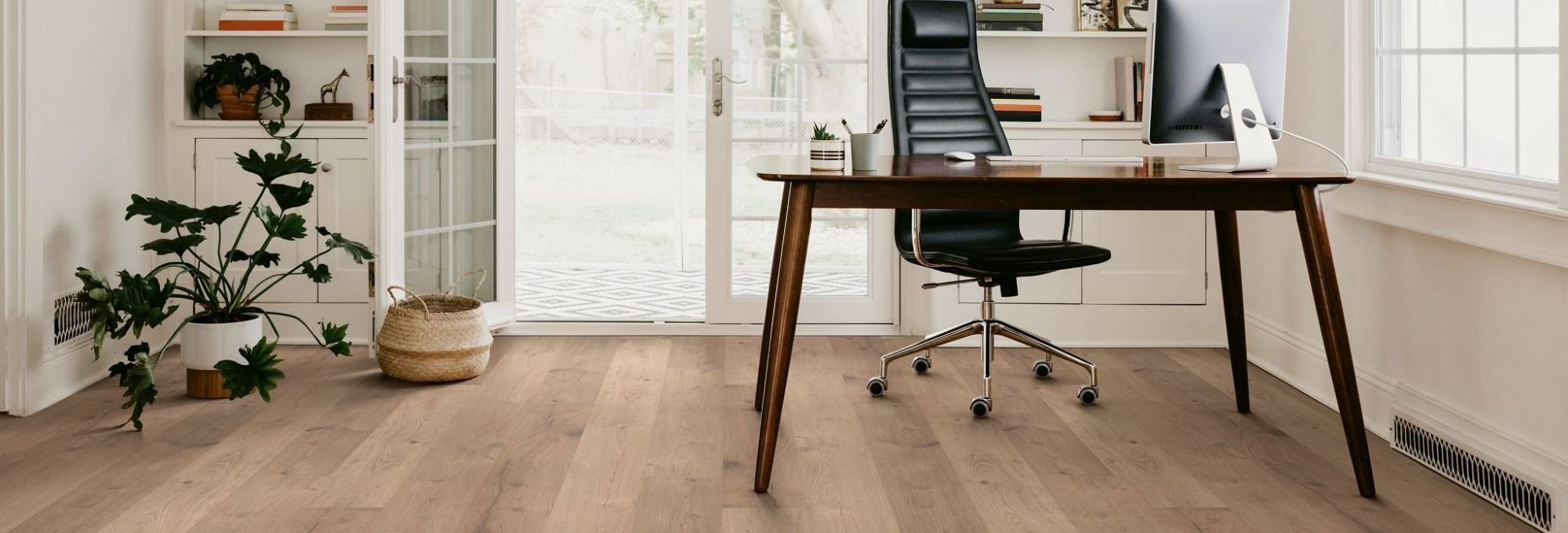 black leather office chair and black office desk on a bright room with brown hardwood floor from Floor Store and Design in Columbia, TN